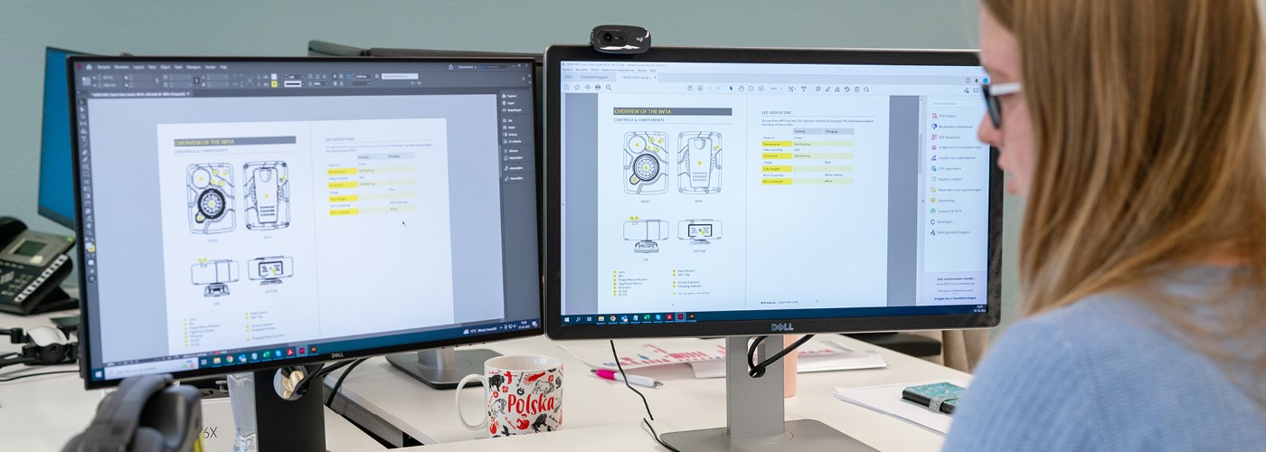 Employee sitting behind two screens and creating a manual