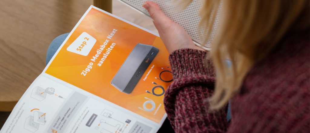 Illustrating real-life use of documentation during a user study:User reading a printed installation guide at home, showing step-by-step instructions for connecting a media box